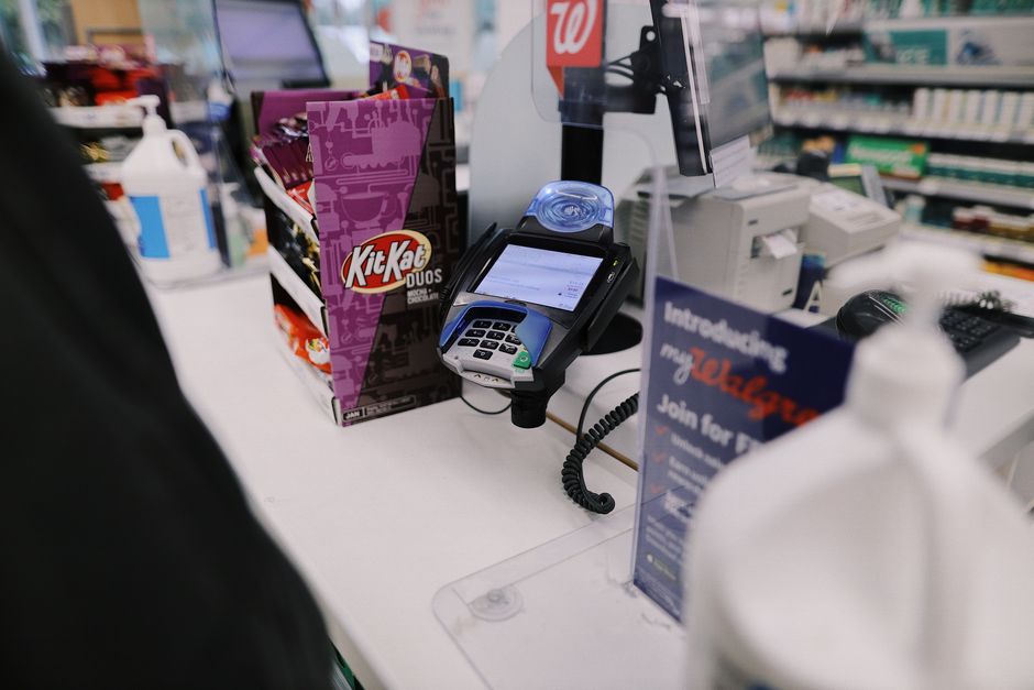 Close-up view of a retail checkout counter with a credit card reader and various goods.