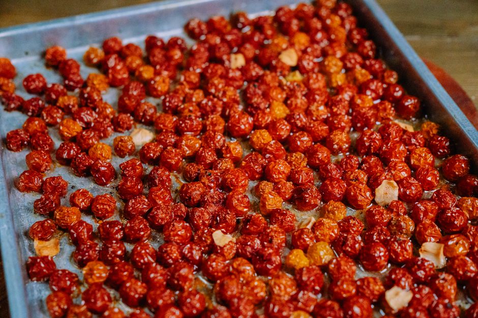Delicious oven-roasted cherry tomatoes seasoned with herbs and spices on a baking tray.